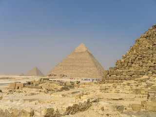 Fototapeta na wymiar Many tour buses and people by great pyramids in Giza
