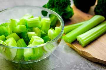 Green vegetable smoothie in glass at gray background