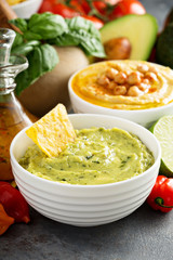 Guacamole and hummus in white bowls