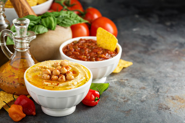 Homemade hummus and tomato salsa in white bowls