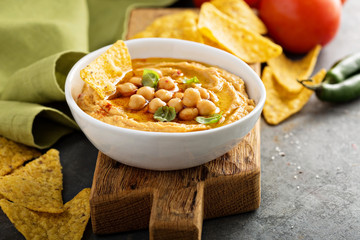 Homemade hummus in white bowl with corn chips