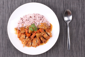 Brown rice with chicken topped Japanese yellow curry.
