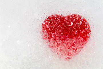 Red heart frozen in ice, macro, selective focus, Valentine's Day background