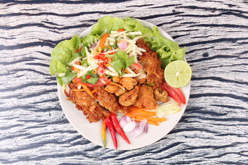 Spicy deep-fried chicken salad with roll green mango .
