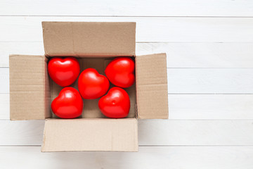 Top view red heart in brown box on white wooden plank. For love