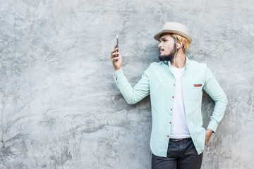 Portrait of handsome young hipster man listening to music.