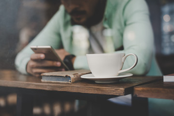 Hipster young handsome man using his smartphone .