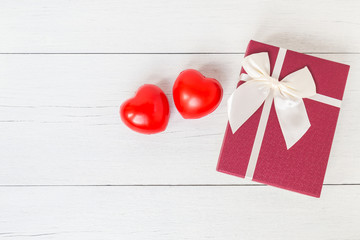 Top view red heart and gift box with ribbon on white wooden plan