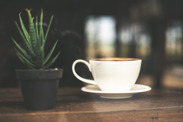 Vintage tone of hot coffee latte art in cup on table.