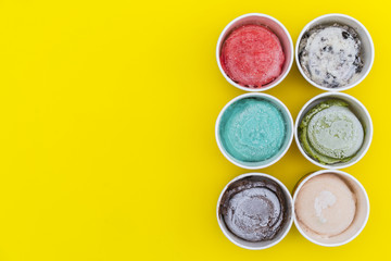 Top view Ice cream flavors in cup on yellow blackground