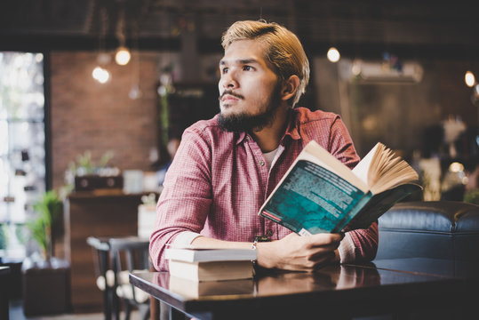 Hipster Bearded Man Reading Book In Cafe.