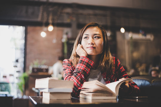 Hipster woman teenager sitting enjoy reading book at cafe. 