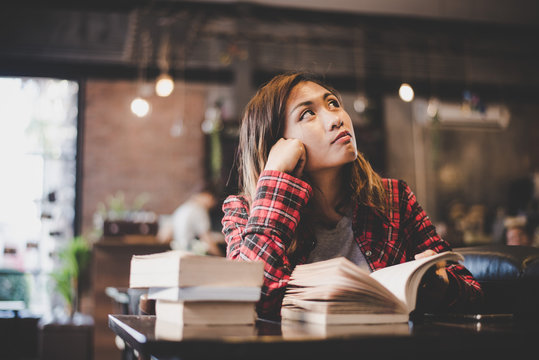 Hipster woman teenager sitting enjoy reading book at cafe. 
