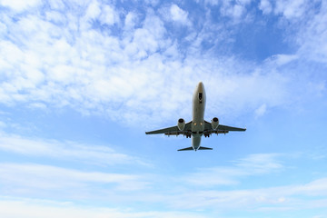 Airplane flying under blue sky and white cloud in Thailand