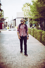 Portrait of handsome hipster man in jeans clothes and sunglasses.