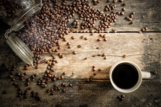 Coffe beans on the grunge wood with cup background.
