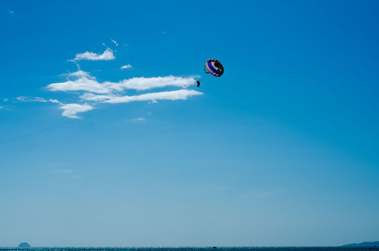 Parasailing couple against bright blue sky