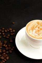 cappuccino and coffee beans on a dark background