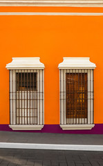 Two windows on orange wall