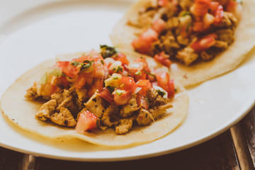 Tacos de carnitas y carne al pastor, comida Mexicana con tortillas.