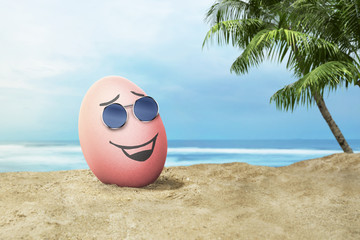 Happy easter eggs with sunglasses in the beach