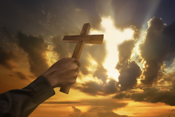 Man hand holding wood cross or religion symbol shape