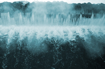 Dam to regulate the water level in the river. Falling water monochrome with strong bursts
