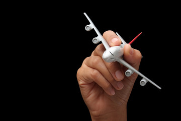 hand holding a model plane on a black background.