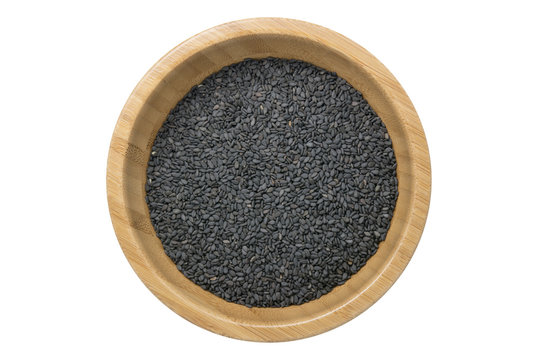 Top view of black sesame seeds in wooden bowl isolated