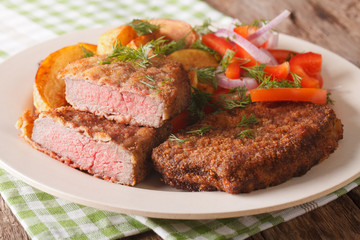 Fried Breaded rump steak with potato and vegetables close-up. horizontal