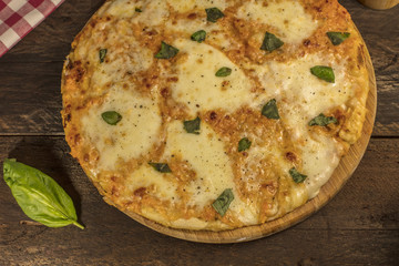 Homemade Margherita pizza on dark wooden table