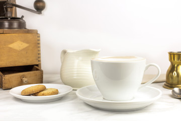 Coffee with milk, butter cookie, milk jar and copyspace