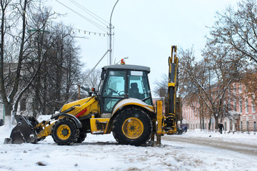 tractor for snow removal is parked on a city street