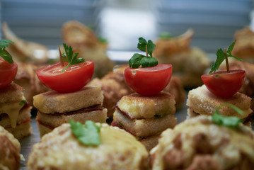 Canapes with stuffed cherry tomatoes on an wooden buffet table.Close up.