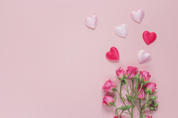 Bouquet of roses and hearts on a pink background. Space for text