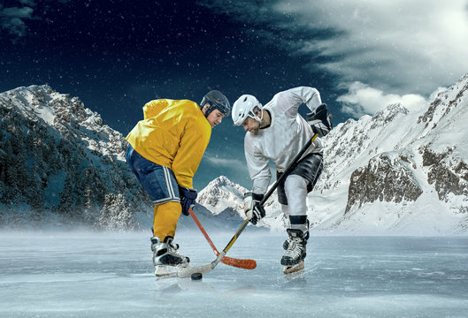 Ice hockey player in action outdoor around mountains