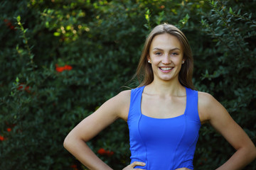 Fototapeta premium Fitness beautiful young woman smiling with hands on waist in nat