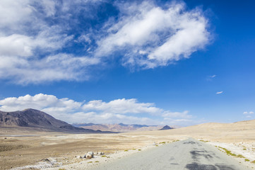 Fototapeta na wymiar Empty dirty off road in Pamir Mountains in Gorno-Badakhshan Autonomous Region, Tajikistan