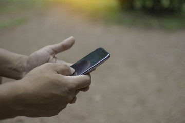 Close up of a man using mobile smart phone outdoor, in hand