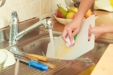 Obraz premium Woman doing the washing up in kitchen