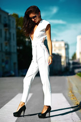 Fashion sexy hot businesswoman girl model in white suit in sunglasses in the street