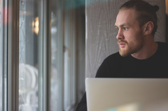 Man is working on laptop while sitting at cafe