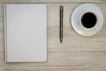 A blank notebook with a pencil and a cofee