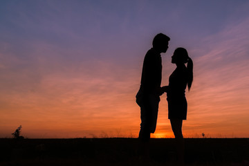 Fototapeta na wymiar photograph silhouette,Young men and young women Show your love during sunset,vintage tone.