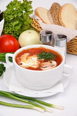 Ukrainian borsch with mushrooms and sour cream on a white plate
