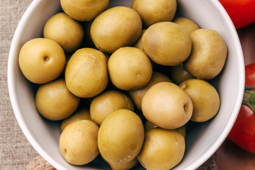 Fresh green olives in white bowl  Top view 