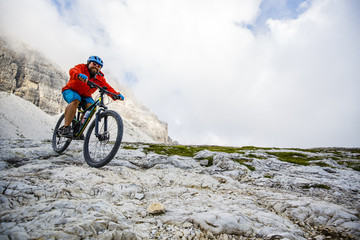 Fototapeta na wymiar View of cyclist riding mountain bike on trail in Dolomites,Tre C