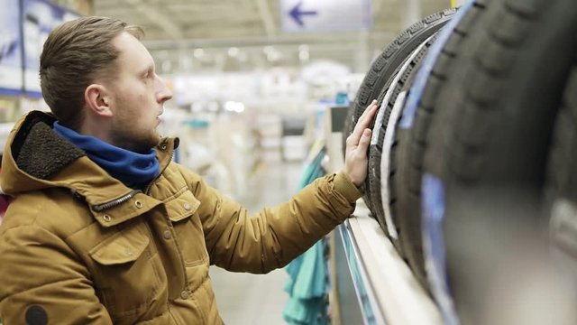 Man chosing new tires in shop