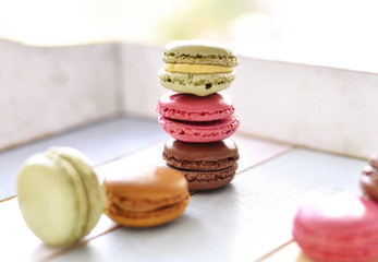 Delicious colorful macarons with cream. Coffee break scene with macaroon candy and selective focus.