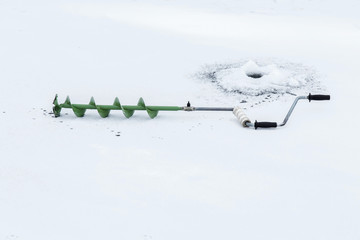 Anglers equipment in the lake ice in winter day. 
